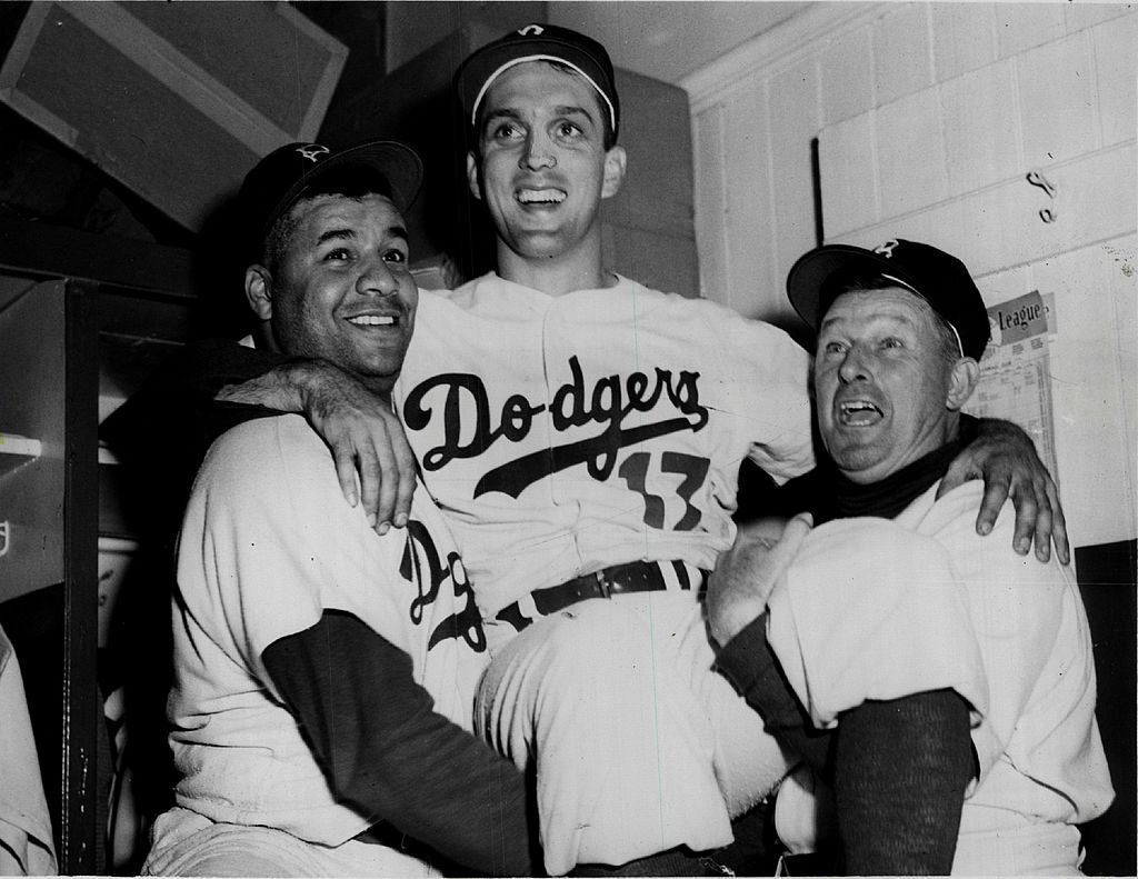 Carl Erskine (C) of the Brooklyn Dodgers is lifted up on the shoulders of catcher Roy Campanella (L) and manager Chuck Dressen (R) after Erskine setting a new all-time world's series strikeout record of 14 during Game Three of the 1953 World Series on October 2, 1953 at Ebbets Field in the Brooklyn borough of New York City. (Photo by Sporting News via Getty Images via Getty Images)
