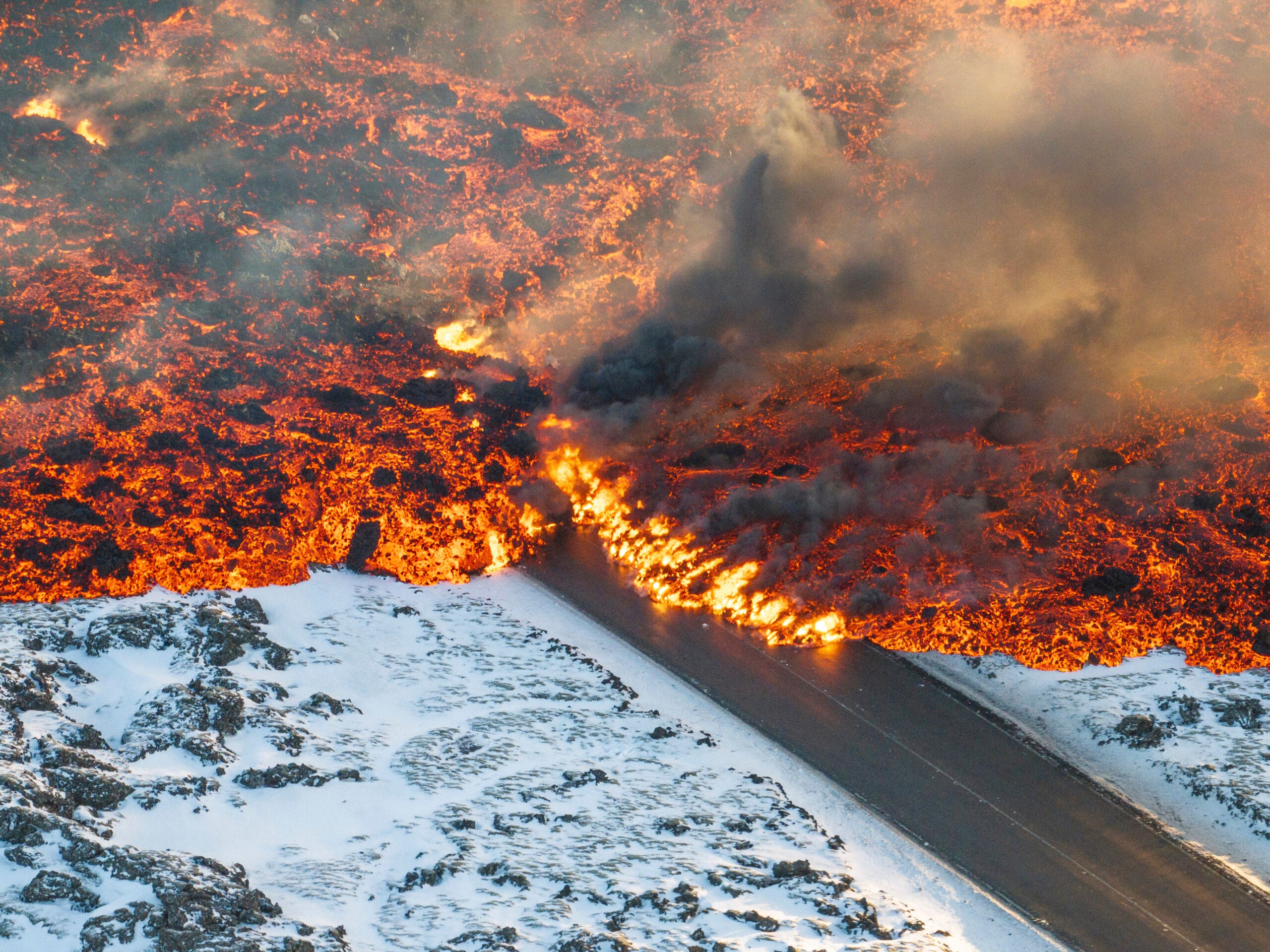 Lava crosses the main road to Grindavík and flows on the road leading to the Blue Lagoon, in Grindavík, Iceland, Thursday, Feb. 8, 2024. A volcano in southwestern Iceland has erupted for the third time since December and sent jets of lava into the sky. The eruption on Thursday morning triggered the evacuation the Blue Lagoon spa which is one of the island nation’s biggest tourist attractions. (AP Photo /Marco Di Marco)