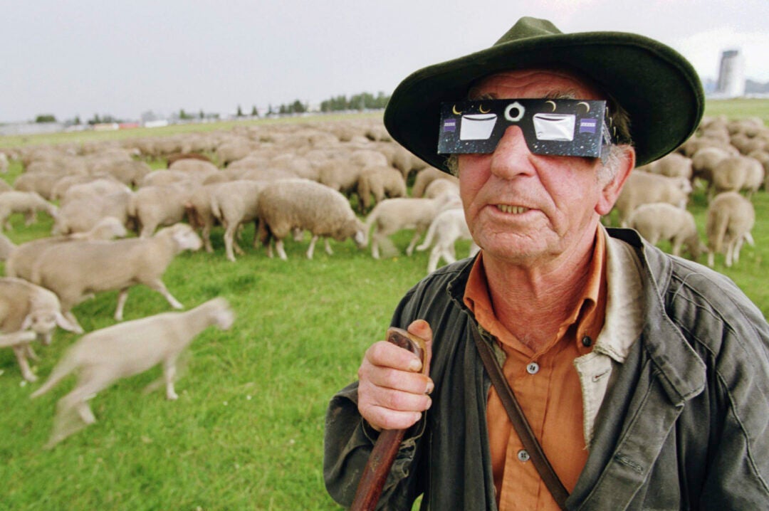 Shepherd Heinz Greiner watches the beginning of a total solar eclipse near Augsburg, southern Germany, on Wednesday, Aug. 11, 1999. (AP Photo/Frank Boxler, File)