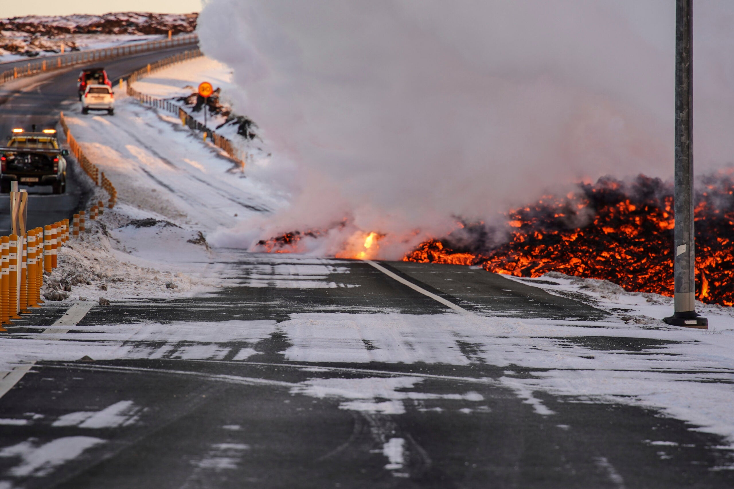 Lava spills onto the road to Grindavík, close to the exit for the Blue Lagoon, in Grindavík, Iceland, Thursday, Feb. 8, 2024. A volcano in southwestern Iceland has erupted for the third time since December and sent jets of lava into the sky. The eruption on Thursday morning triggered the evacuation the Blue Lagoon spa which is one of the island nation’s biggest tourist attractions. (AP Photo/Marco Di Marco)